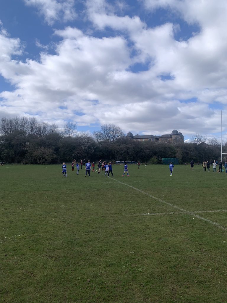 Playing fields with children in blue and white stripe shirts