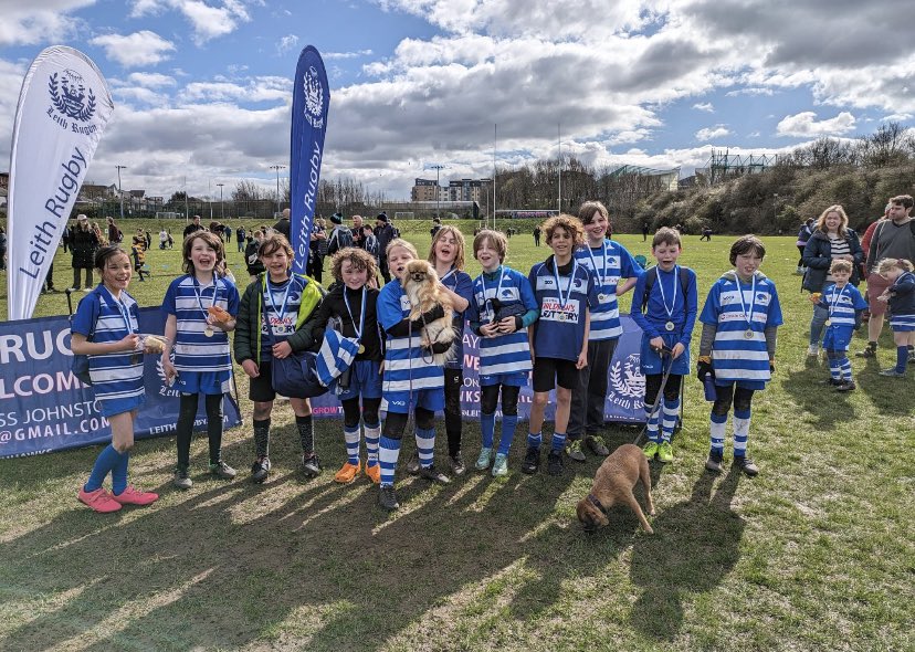 Group photo shows children on playing field gathered together wearing Leith Hawks blue and white stripe shirts wearing medals